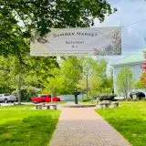 summer market banner hanging over town park