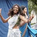 two girls smiling while performing classical indian dance