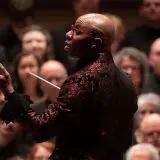 close up of chorus conductor with audience in background