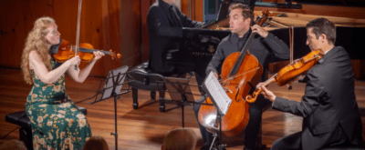 a string quartet performs, looking engagingly at one another