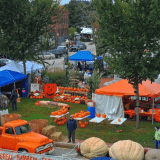 birds eye view of pumpkin festivities including orange and blue tents and trucks